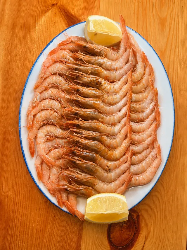 Fuente de gambas frescas con limón, servidas al peso
